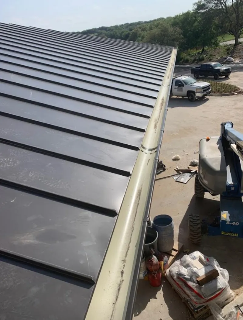 Standing seam panel and gutter detail on a metal roofing jobsite in Davie